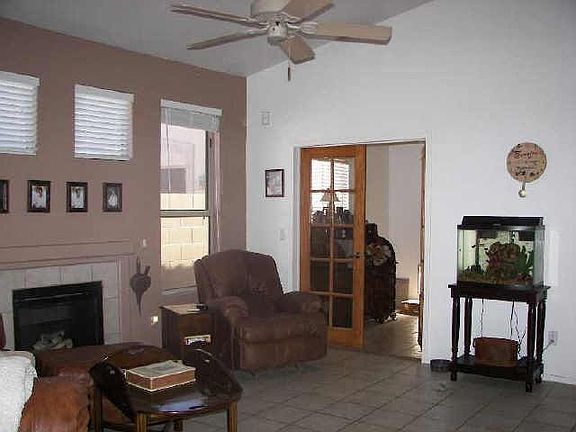 Fireplace and vaulted ceilings in living room with french doors to office