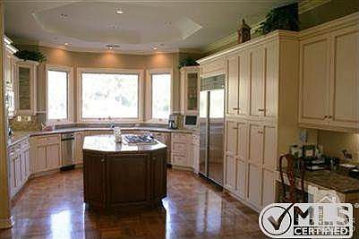 Gourmet kitchen features granite counters, updated appliances,center island, and large a joining eating area that over looks side patio featuring built-in BBQ center.