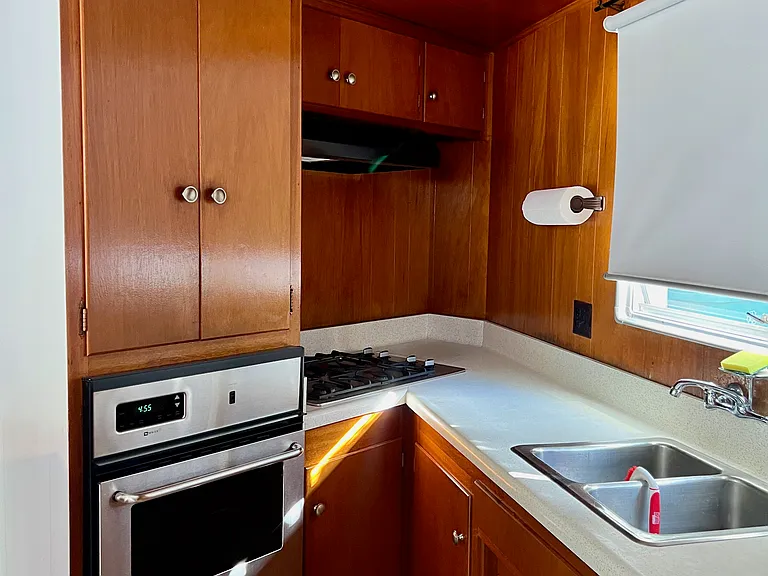Oven, overhead fan, stove, kitchen sink countertop, back patio window