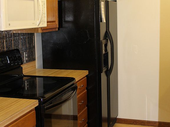 The galley kitchen is complete with electric stove and microwave, refrigerator and dishwasher.