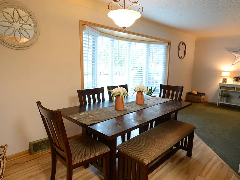 Dining room offers expansive views of front gardens. Open to kitchen and living room for socializing with friends and family. Low maintenance laminate wood floor makes clean-up a breeze.