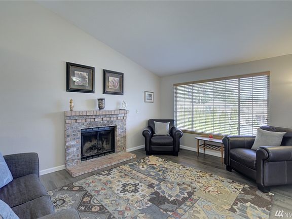 The living room, located just off the foyer features fresh paint, all new flooring and a wood burning fireplace. 