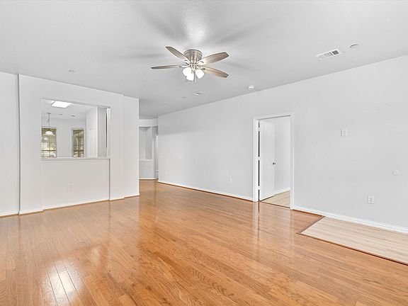Living room with view toward the kitchen and primary bedroom.