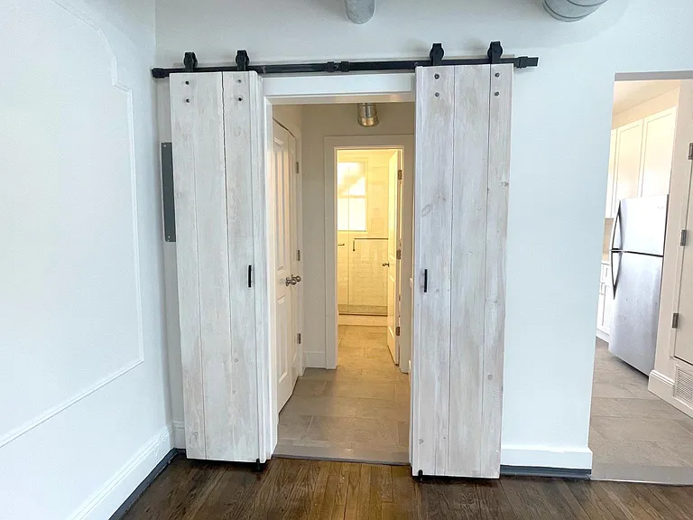 Entry to Bathroom and Linens (l) with KItchen (r) from Living Room