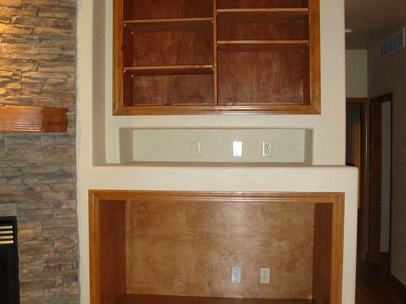 Built in entertainment shelving with attached rock accent wall gas fireplace
