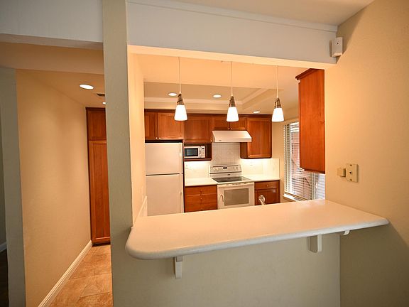 View from dining room into kitchen. Canned lighting with murano lights over bar.