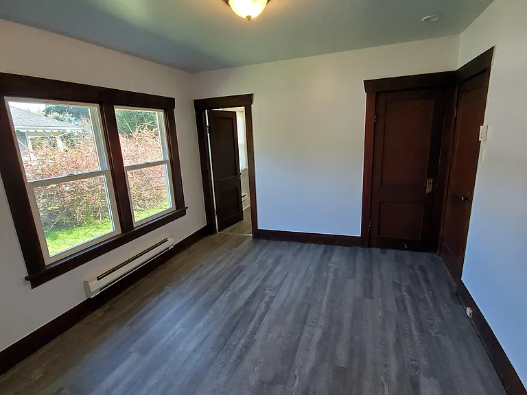 Back bedroom with corner closet, and door leading to dining room.