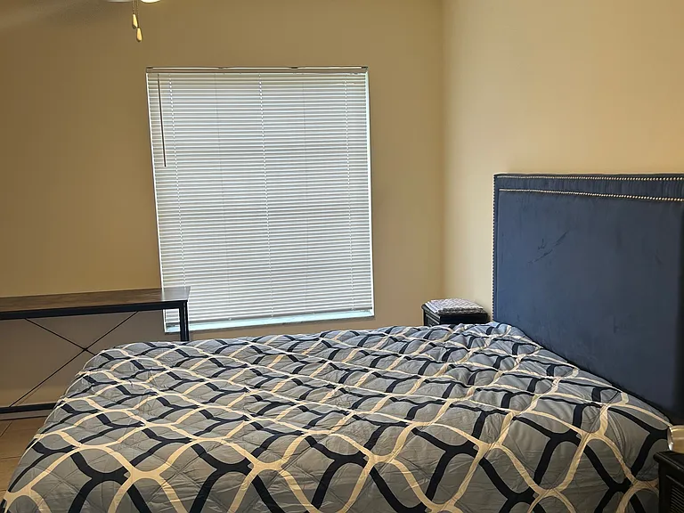 master bedroom with queen bed, two night stands, dresser and desk