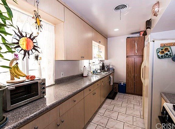 Kitchen: View from Dining Area. Utility room w/washer dryer at end of kitchen.