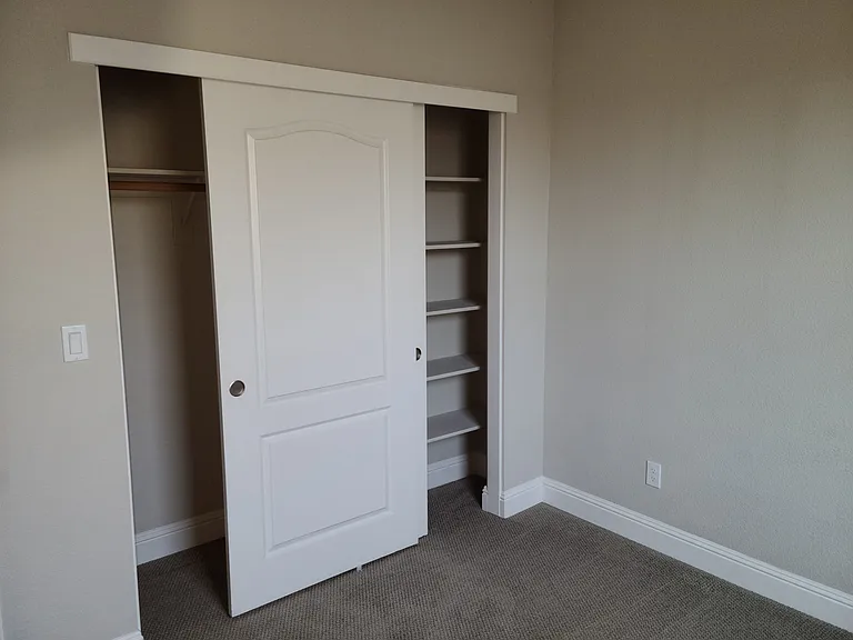 Inside view of the second bedroom closet. The closet has built-in shelves.