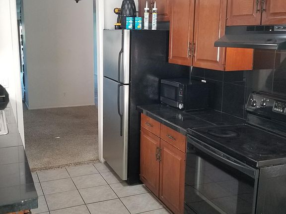 Kitchen with dishwasher, range refrigerator and countertop microwave.