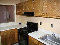 KITCHEN WITH TILE FLOOR, STAINED OAK CABIENTS, GAS STOVE 