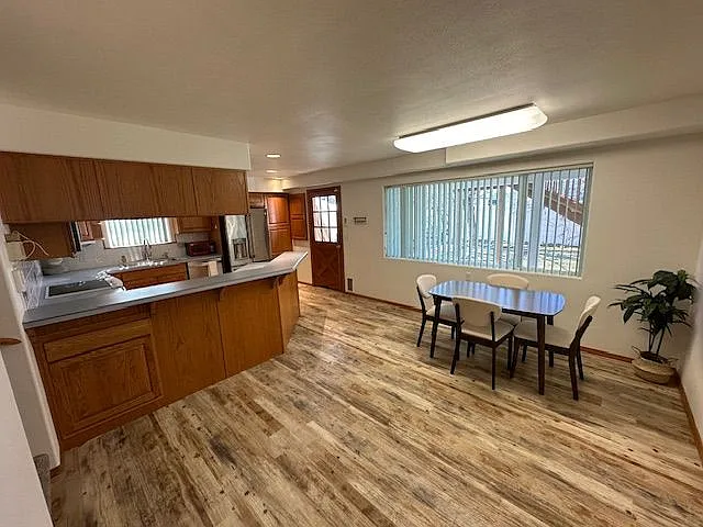 Spacious kitchen with ample canet space, stainless steel refrigerator, dishwasher, microwave, and recessed lighting.