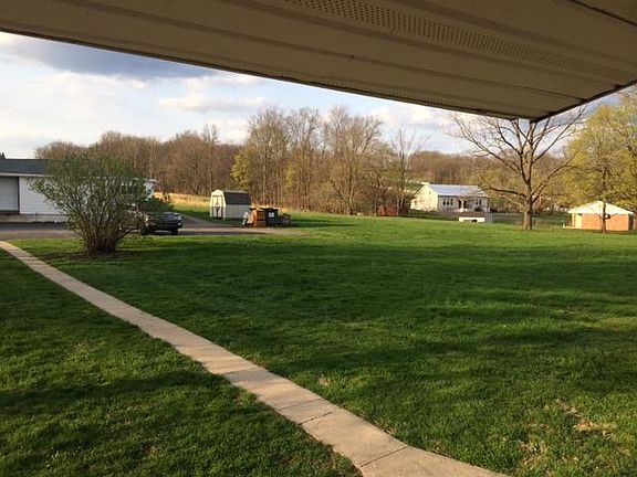 Yard view from back porch, sidewalk leads to parking.