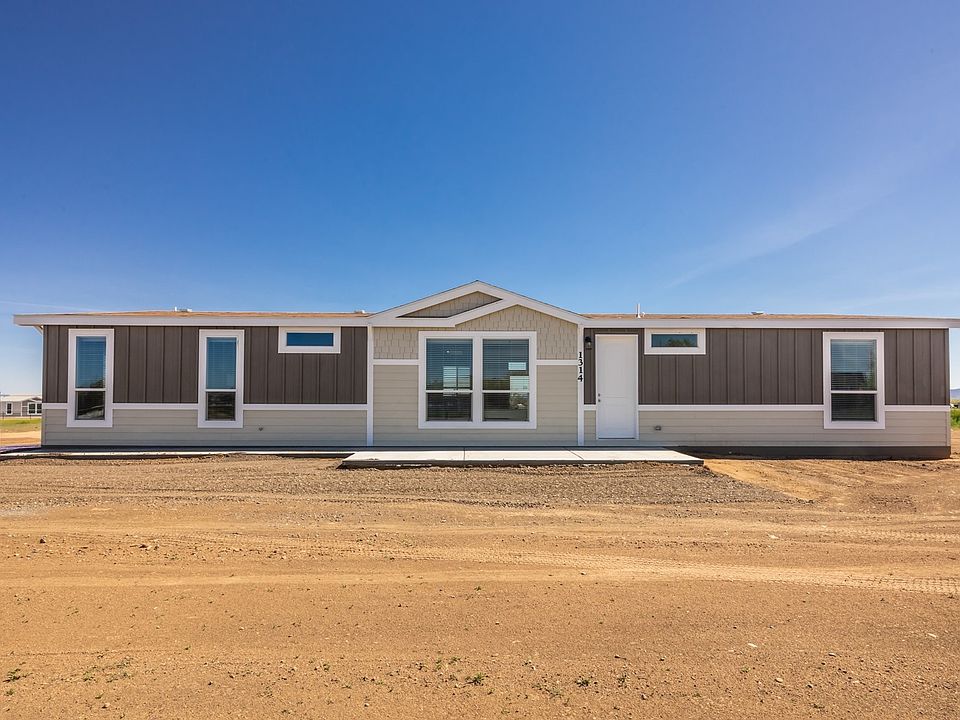 Front view - Nice front patio, over-sized Low-E vinyl windows, wide overhangs and accents, 2x6 construction, upgraded board & baton/lap concrete board siding, upgraded insulation.  Level ground set with concrete block stem wall.