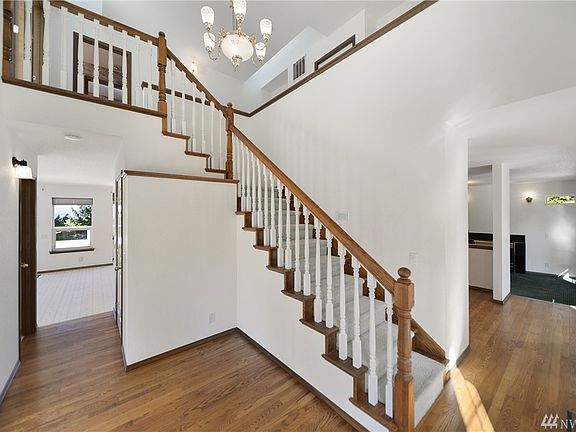 Dramatic entry with hardwood floors and chandelier.