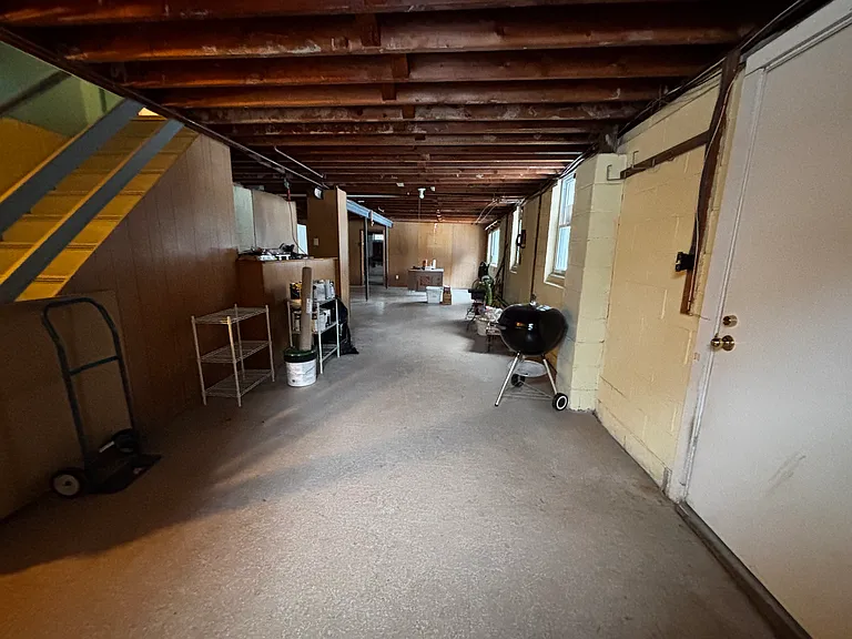 Unfinished heated walkout basement with laundry in the back and walkout to patio and large fenced yard
