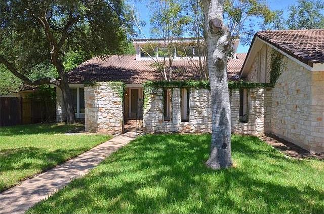 This home has been extensively remodeled with several updates. It has mainly a stone exterior plus a tile roof . The lot has several mature tree and shrubs. It backs up to the private Onion Creek Golf Course and the original Number 7 Fairway.