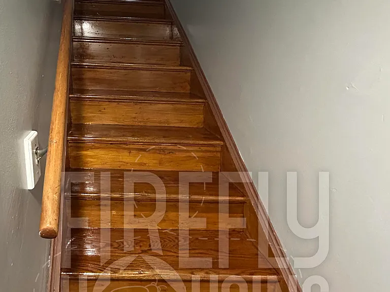 Stairway viewed toward upstairs with newly resurfaced hardwood floors/stairs.