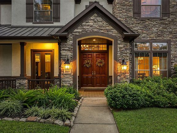 Gorgeous stacked-stone and lush landscaping compliments this stucco home.