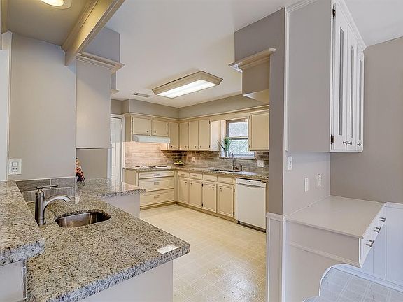 Updated kitchen with granite counters, modern subway style back splash, real wood cabinets and pull-out pot and pan drawers under the stove.