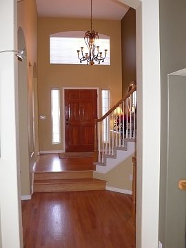 A vaulted ceiling oak flooring create an impressive foyer