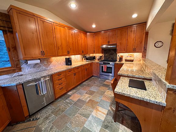 Dishwasher, Refrigerator, stove, microwave, small appliances, and a desk area for a laptop