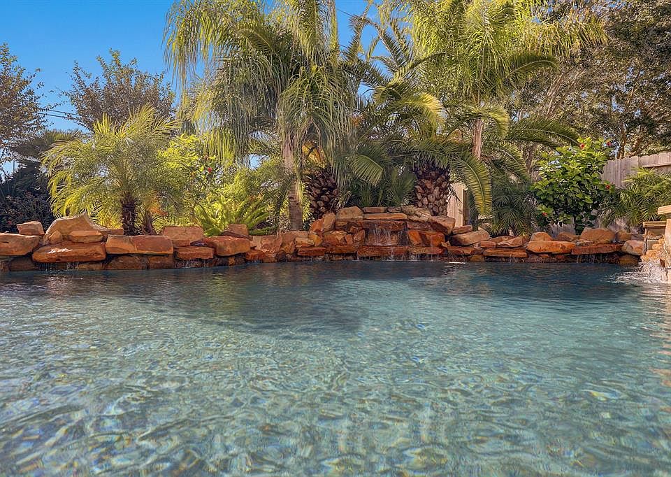 Lush palm trees surround stone and rock waterfall! Over 6ft deep, saltwater pool & Spa!