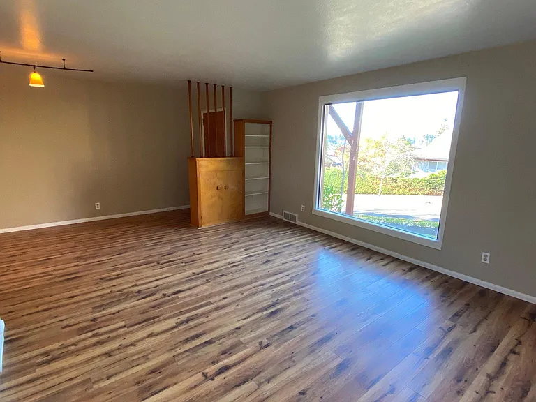 Front room with large picture window and built-in cabinets. There is a ton of built-in drawers, cabinets and closets throughout the home.
