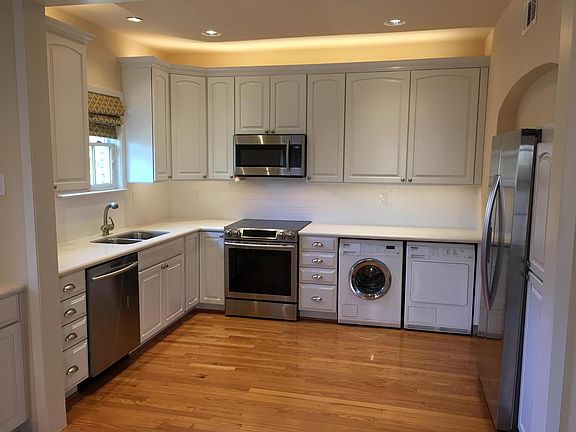 Remodeled kitchen with hardwood floor, new cabinets, stone countertops, Samsung appliances and Miele washer and dryer