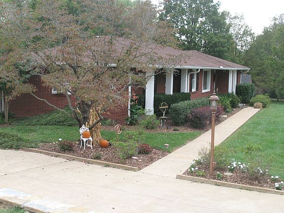 Side photo with walkway, Dogwood tree, and automatic post light