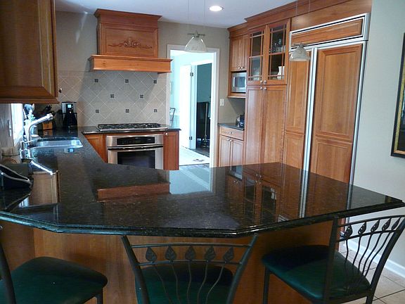Updated kitchen with granite counters, cherry cabinets & integrated appliances
