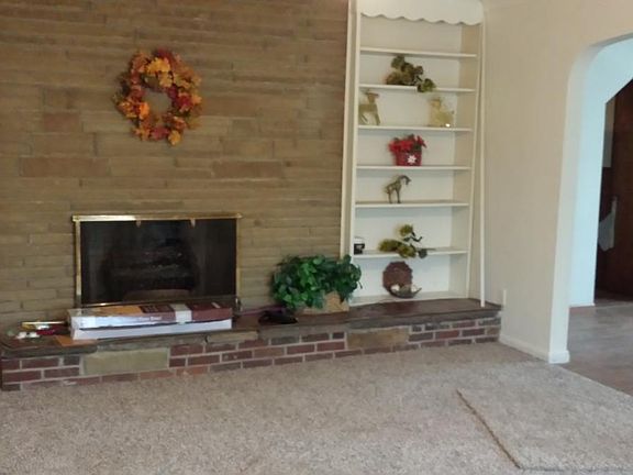 Stone fireplace wall with ledge and shelving