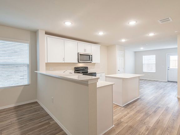 Spacious island kitchen with eat-in peninsula bartop.