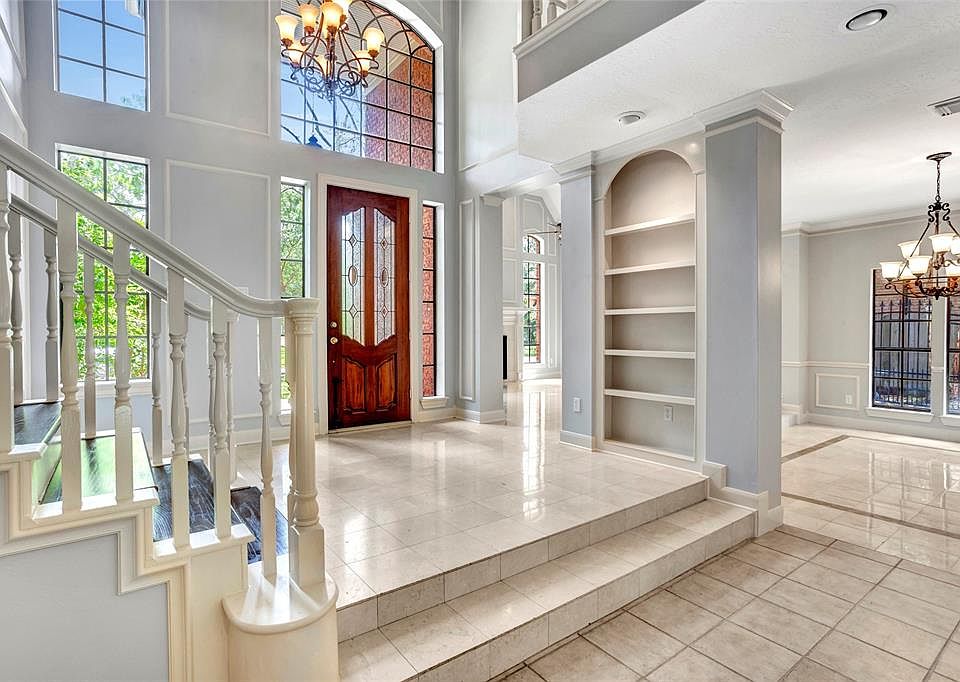 The GRAND foyer will greet you as you enter into the STUNNINGLY beautiful home. Note the light fixtures and curved architecture, and marble/tile floors throughout this home