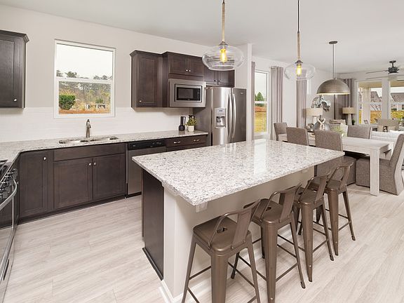 Spacious kitchen area with a window above the sink, beautiful countertops, and a large island.