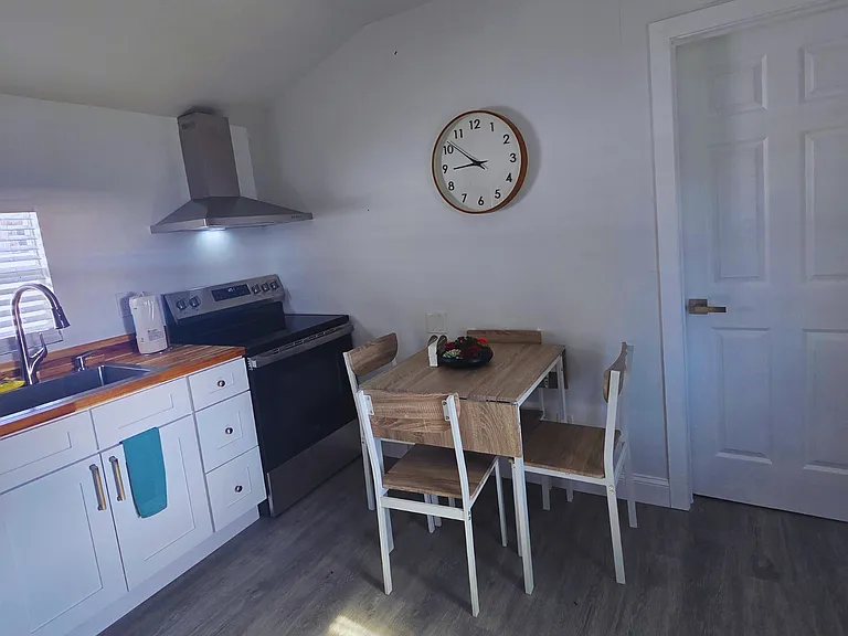 Cozy dining space with seating for 4 and a decorative clock