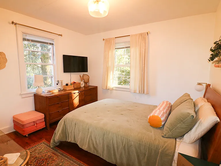 Master bedroom with a queen bed, large dresser, and smart tv
