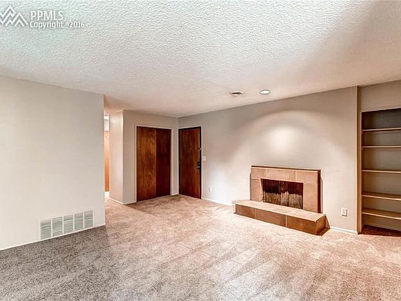 Living Area with Wood Burning Fireplace and Book Shelves. New Carpet