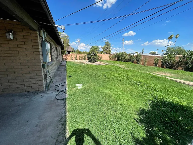 Large covered patio with landscaped backyard, large grass area, & oleanders for additional privacy along back wall