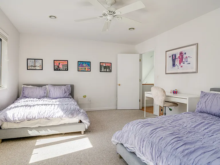 Second bedroom on upper level with two full beds.