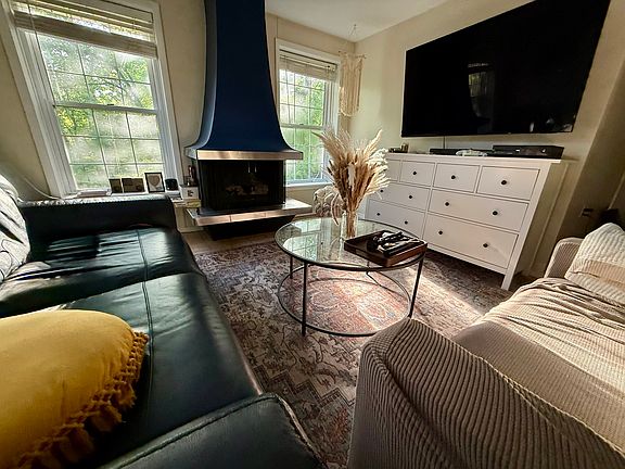 Furnished living room with two couches, smart TV, and board games _ air purifier included, dual-mode overhead lighting flips from bright white for daytime to warm amber for evenings
