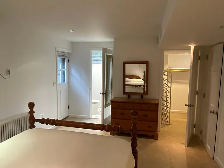 lower level bedroom with walk in closet on right and bathroom on left