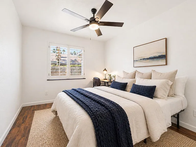 Wood flooring, Queen Bed, desk, chair, lamp, fan, mirrored closet.
