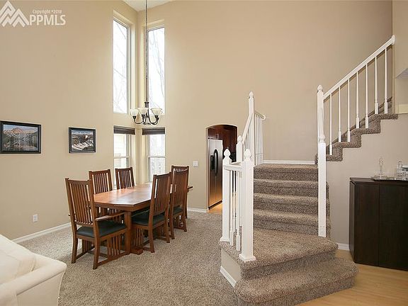 View from entry of stairs and dining area with vaulted ceilings