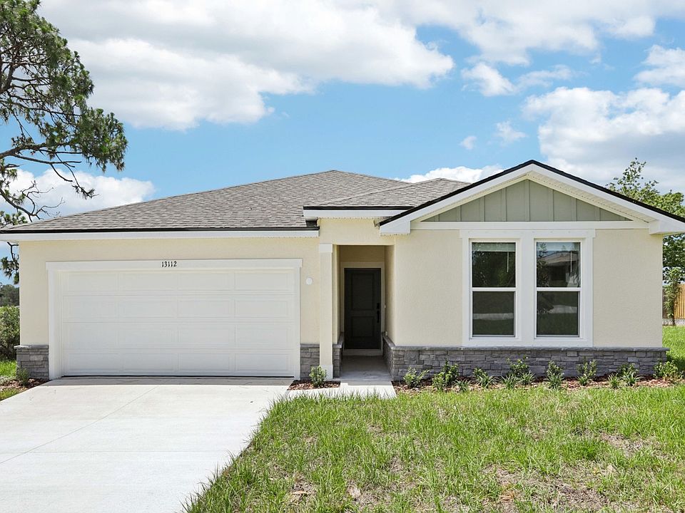 Experience elegance in Spring Hill. This home features a gabled roof and stone accents for timeless