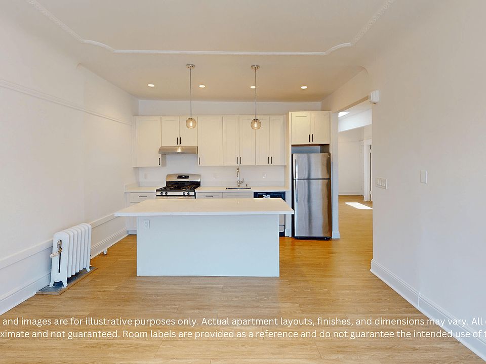 Modern kitchen with cabinetry, a stainless steel fridge, and oven. An island counter, pendant lights, and wood flooring create a clean, open look.