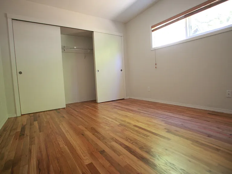 larger bedroom with ribbon window and large closet
