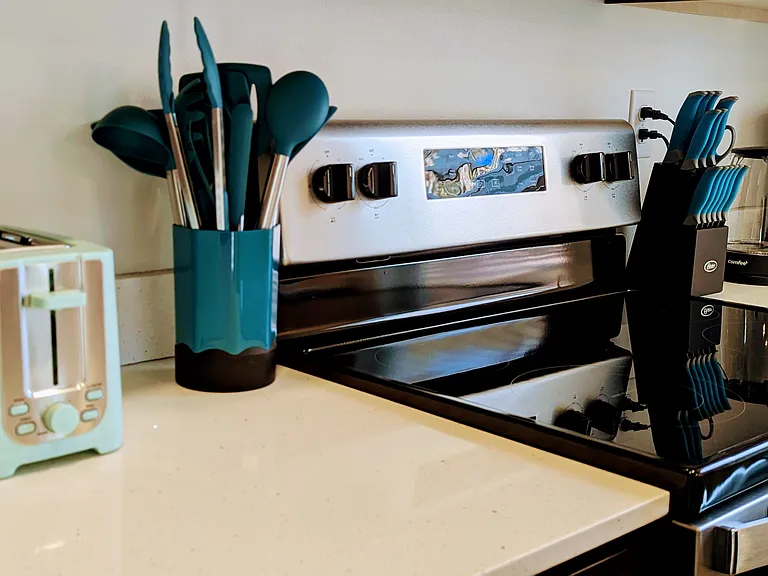 Toaster, blender, mixing bowls, kitchen utensils, cutlery, pots, pans, baking dishes and cookie sheets, electric griddle, dish towels, hot mitts and mats, dishes, glassware, coffee cups, placemats.