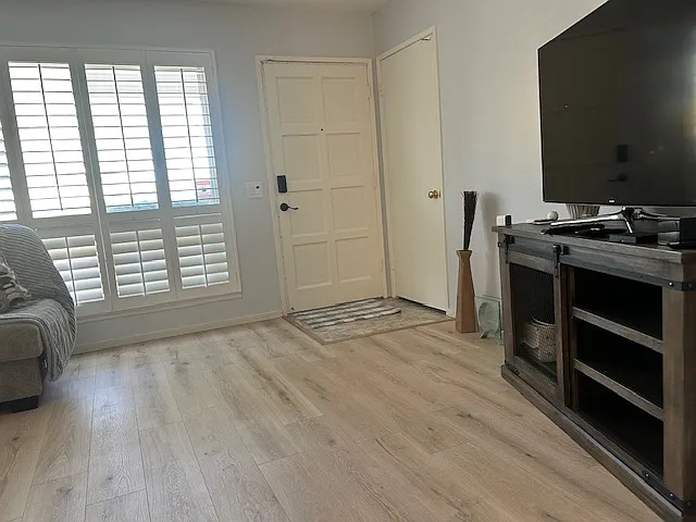This is the entrance to the living room, featuring new flooring, fresh paint, well-maintained and renovated doors, and LED lighting.